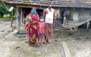 Sankar* with parents before their house