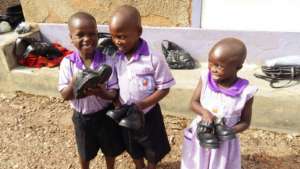 Nyaka Primary students holding their new shoes