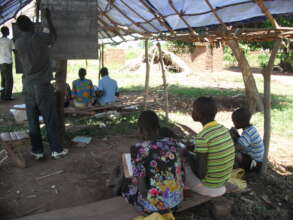 First classroom, students sat on tree logs