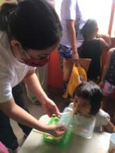 Volunteer assisting a child to finish her meal