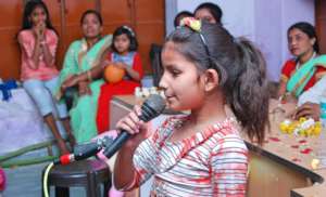 A girl child sharing her experience with audience