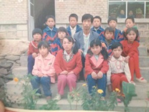 Xiaojie with her teacher and classmates in school