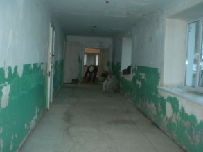 Floor in the hallway, bathroom is seen in the back