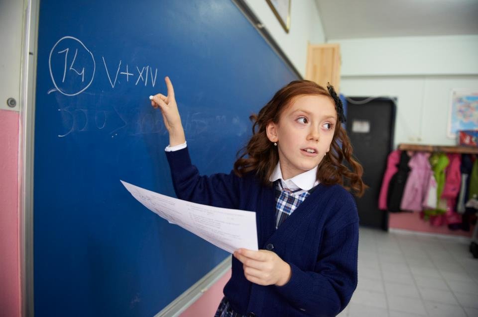 A girl student writing on the blackboard