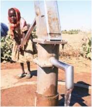 Little girl filling up her jerry can at a handpump