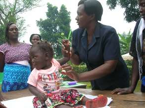 Health workers check on health os kids