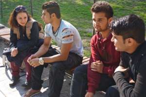 Sanja speaking with three young men