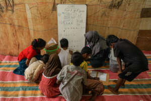 Rohingya refugee children learning in a camp.