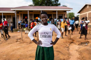 Harriet posing outside her school in Uganda.