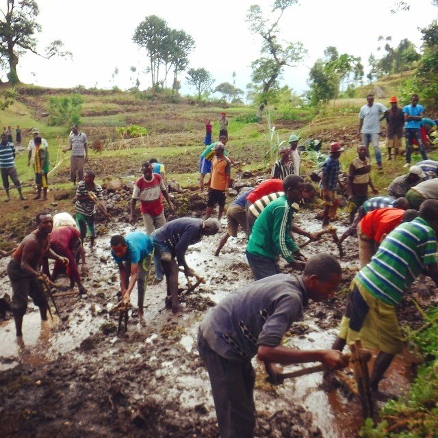Villagers help dig into the source of the spring
