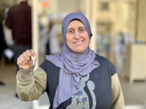 Khadija holding her house key from Syria