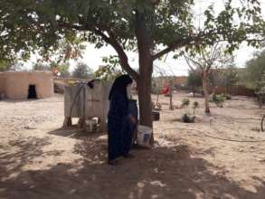Maya waters her family's fruit trees.