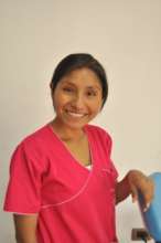 Aracely smiling in her bright dental uniform