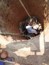 A builder hand digging a well
