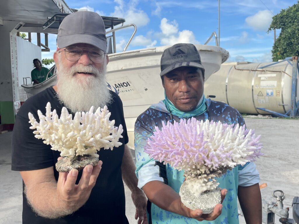 Austin with Kirbati man holding up bleached coral