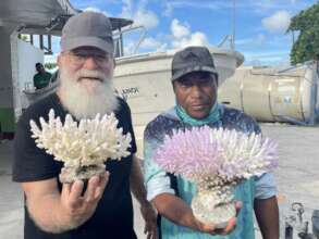 Austin with Kirbati man holding up bleached coral