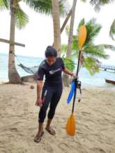 Fiji diver with paddle beside palm
