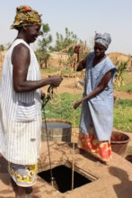 Two local women chat while working in the garden.