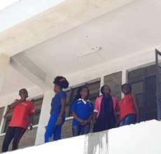 Beneficiaries outside sewing classes for break.