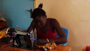 A beneficiary at the GEC sewing a shopping bag