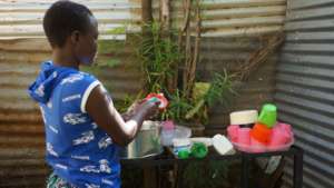 Beneficiary washing dishes at the GEC after meal