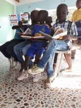 Reading in their new classroom at Maison Kimbilio