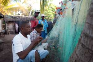 Fisherman repairing his net