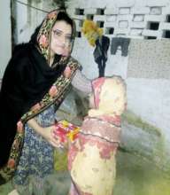 Kainat giving food supplies to an orphan