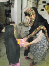 Kainat giving food supplies to an orphan