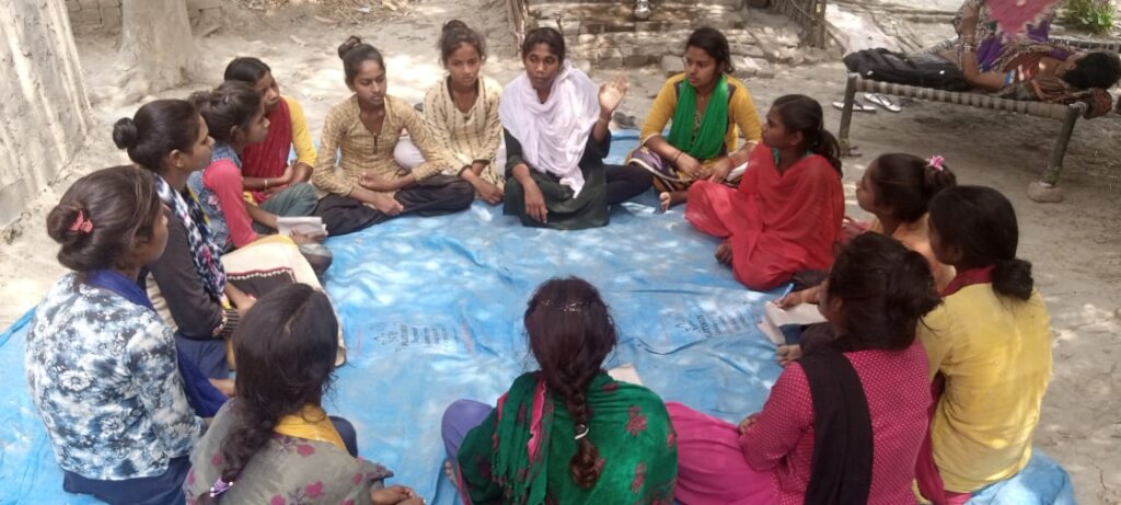 Anjali conducting a meeting in her community