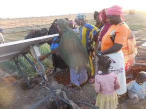 Women showing how they operate the pump