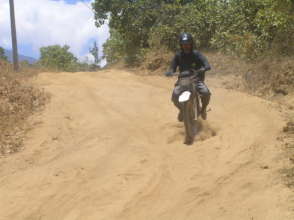 EBPP teacher rides to school on trail bike