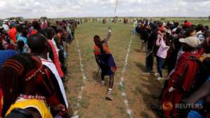 A Maasai warrior throws a traditional club.