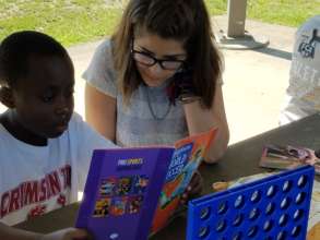 Jacques, reading with a host community volunteer