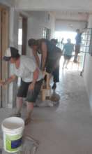 Volunteer Rachael and parents painting at Akili