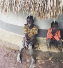 Two boys at their home near a water point in Aduku