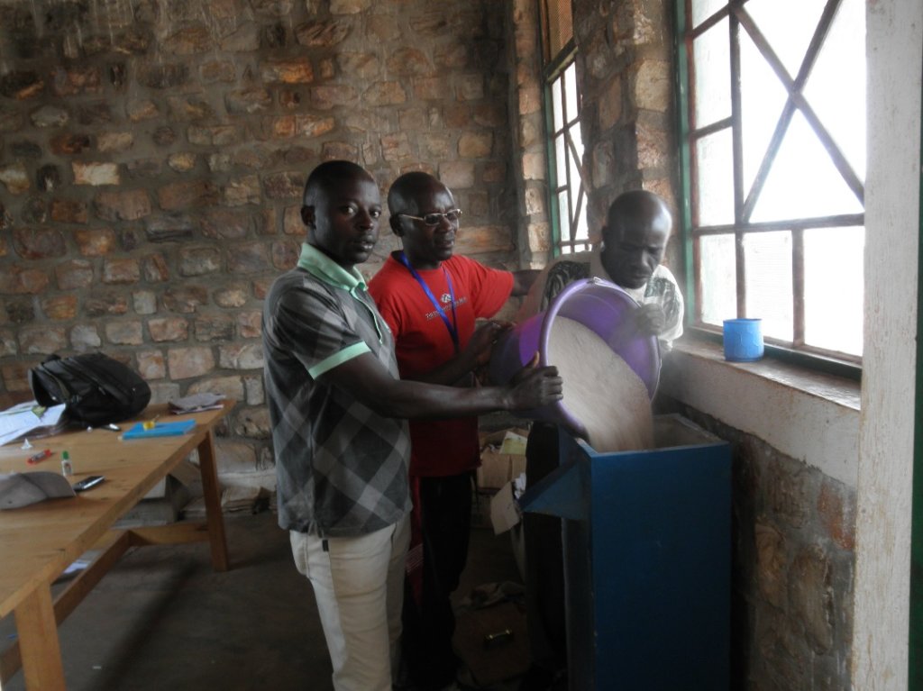 Educators adding sand to the water filter system