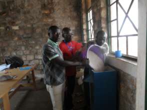 Educators adding sand to the water filter system