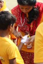 A volunteer bandages an injured child during UCD