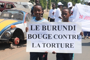 Burundian kids hold a poster: “Burundi moves forward again"