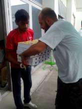 Volunteer giving boxes with food to a refugee