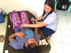 Our midwife, Geo, gives a girl a prenatal checkup.