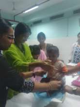 Participants weighing a child on weighing scale