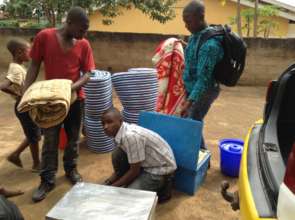 Evode (far right) organizing his school materials