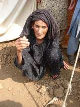 Elderly IDP sitting outside her tent
