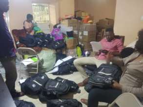 DASL team organizing book bags and school supplies