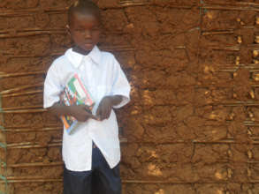 Hekima outside his home with new uniform & books