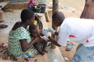 A Community Health Worker treats a child at home