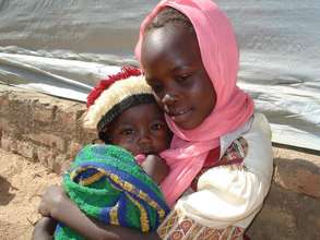 Darfuri girl and her brother outside class tent