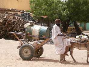 Staff member delivers water to Kutum-area school